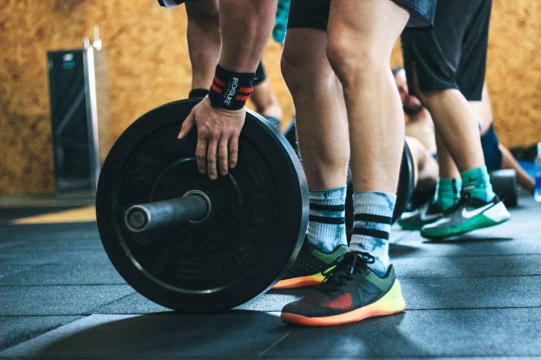 Close-up of a lifter gripping a barbell loaded with weight plates
