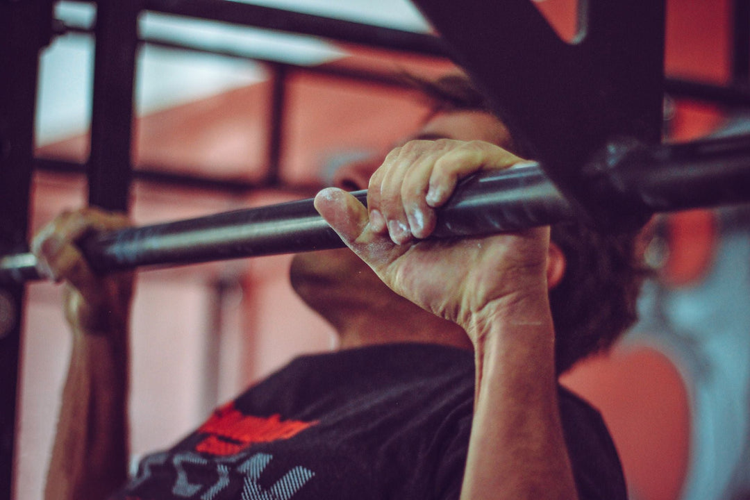 Man doing pull-ups on an overhead bar