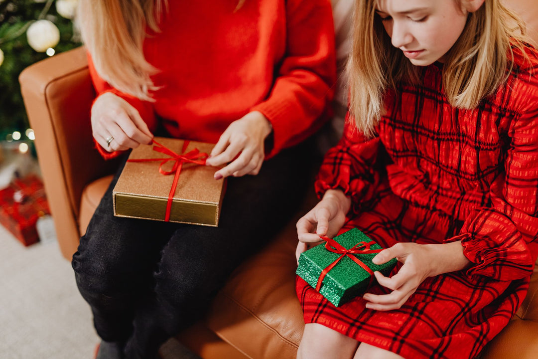 Mother and daughter opening Christmas gifts in a cozy living room