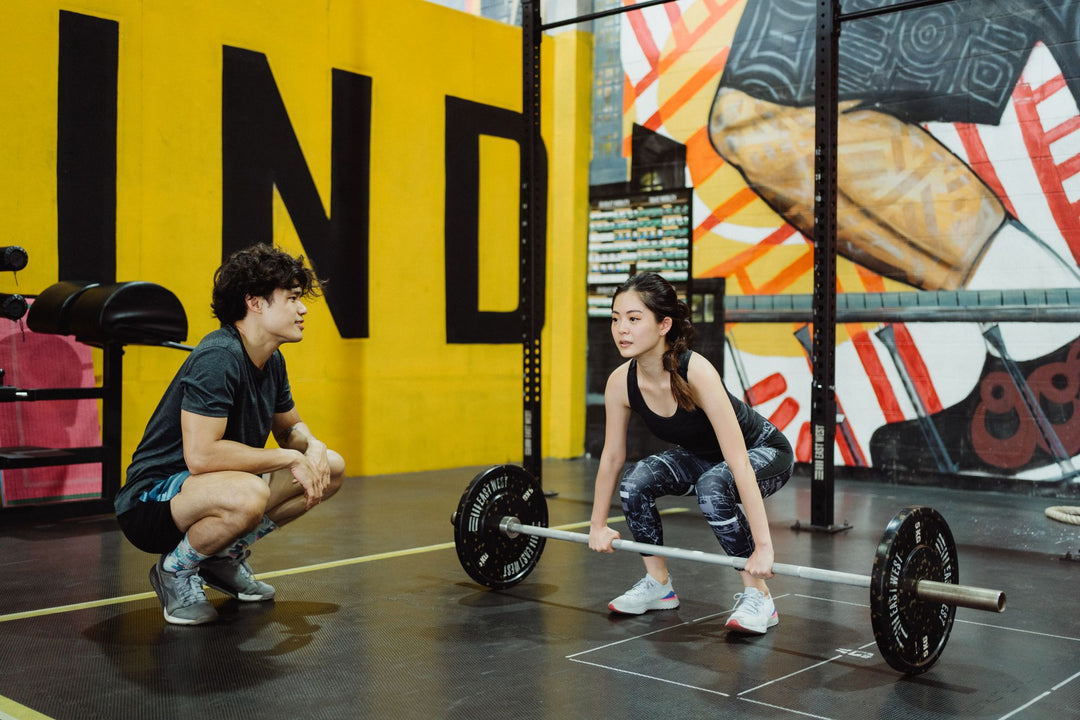 Personal trainer coaching a woman through a weightlifting session